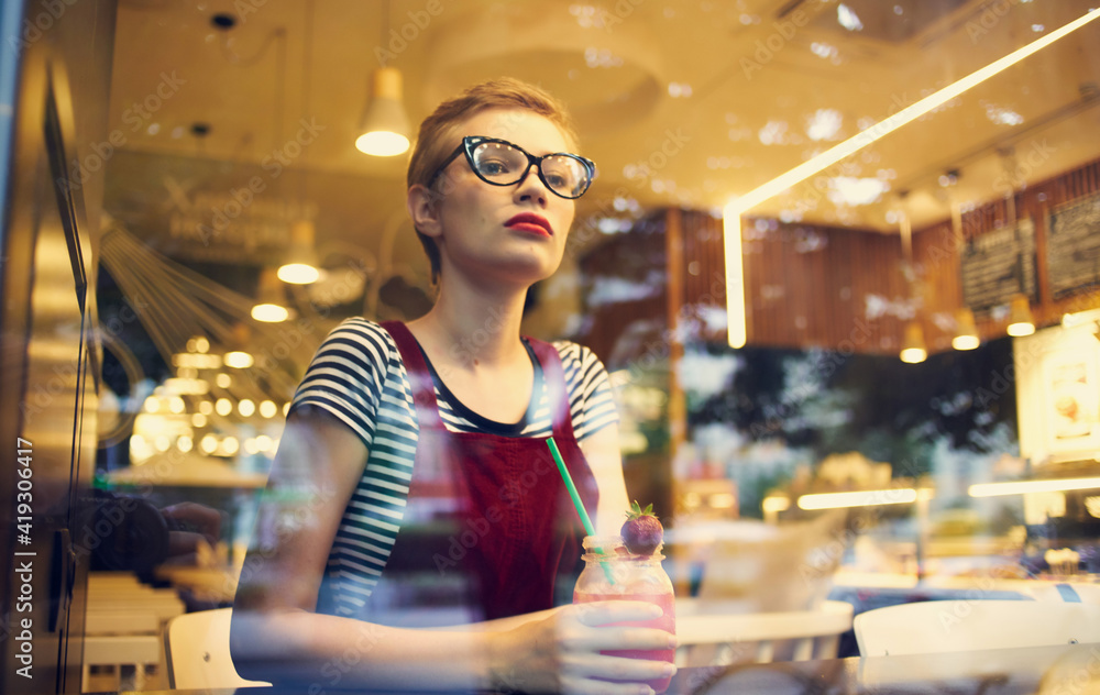 fashionable woman in red sundress resting in a cafe with a drink fashionable woman in red sundress resting in a cafe with a drink