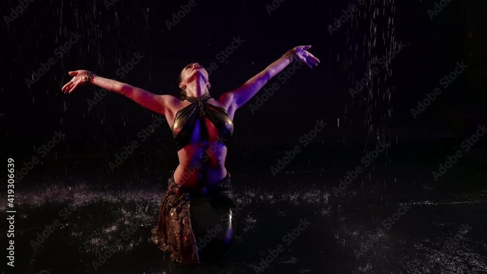oriental priestess is dancing traditional dance under rain, sexy woman is dancing exotic dance oriental priestess is dancing traditional dance under rain, sexy woman is dancing exotic dance