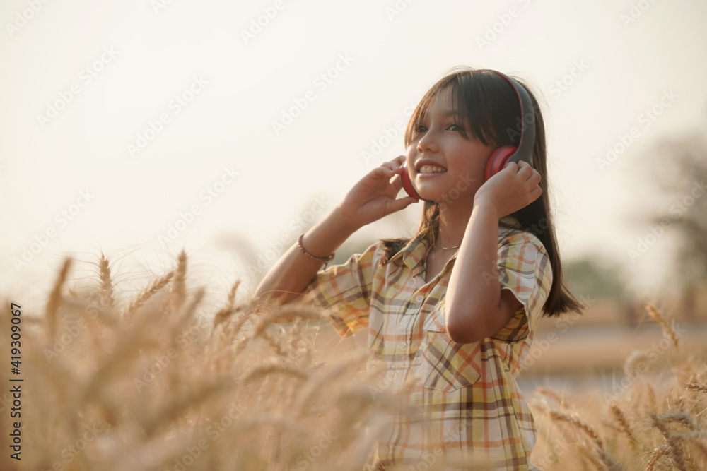 Happy girl in golden wheat field evening sunset on summer vacation Happy girl in golden wheat field evening sunset on summer vacation