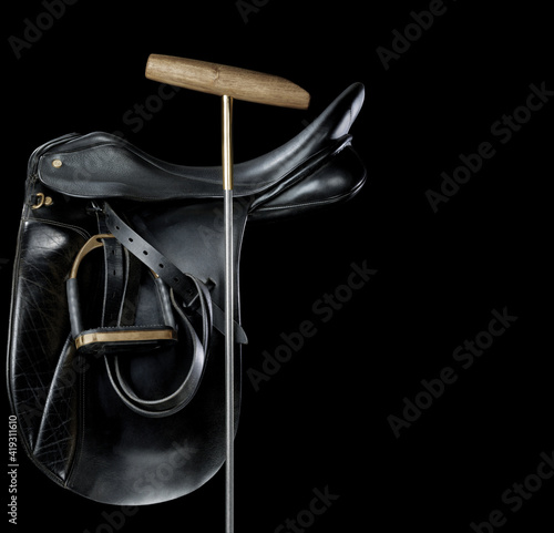 Polo game saddle with club on black background