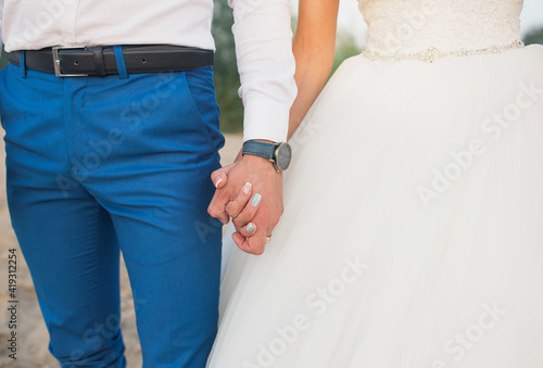 bride and groom hold each other's hands, close-up shooting
