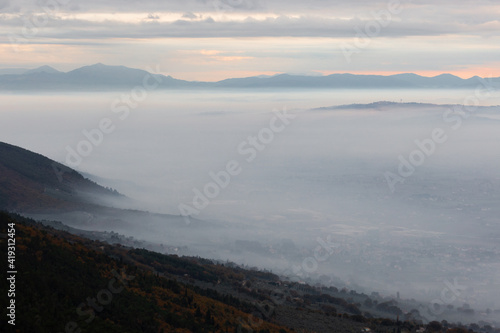 Mist and fog between valley and layers of mountains and hills at dusk  in Umbria  Italy 