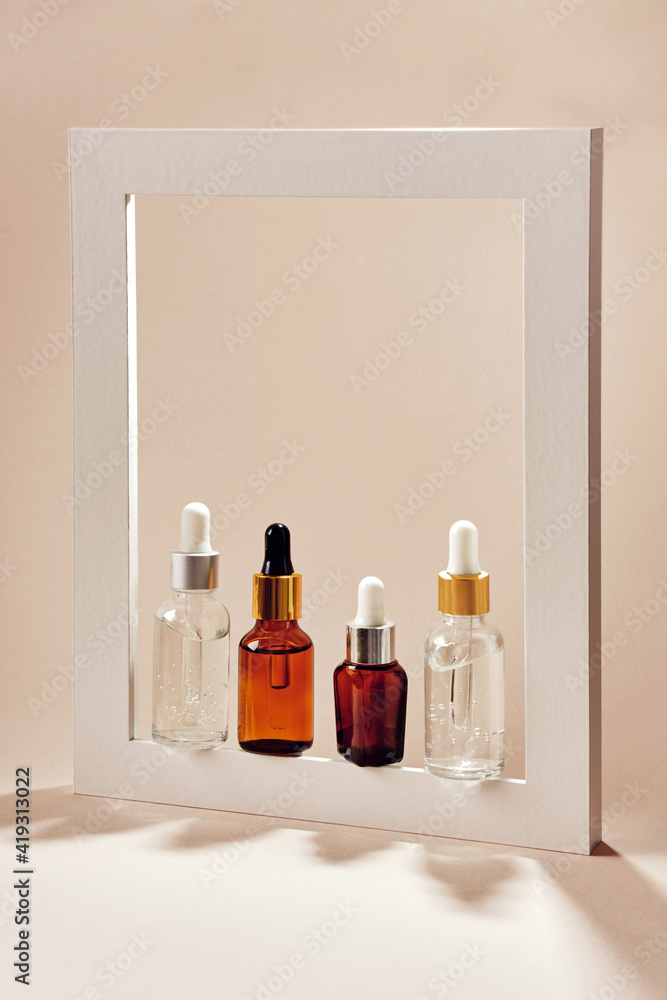Anti-age cosmetic. Skincare collagen serum bottles. Neutral backgrounds and hard shadows Anti-age cosmetic. Skincare collagen serum bottles. Neutral backgrounds and hard shadows
