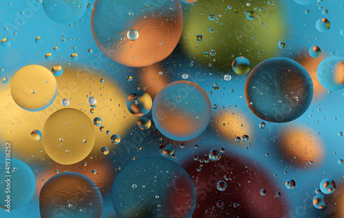 Oil bubbles on water abstract form in glass tank.