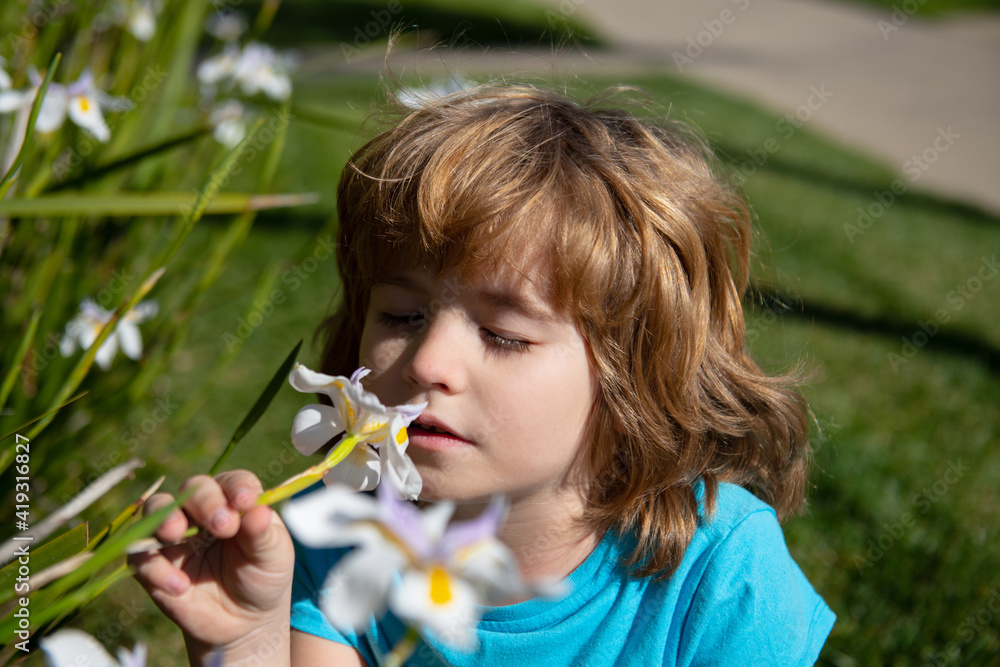 Little boy smelling flower outdoor. Kid sniffing white flowers. Kids allergy. Little boy smelling flower outdoor. Kid sniffing white flowers. Kids allergy.