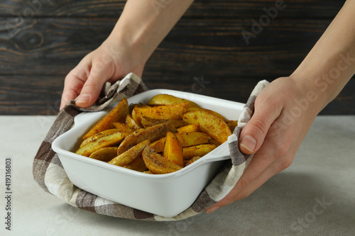 Female hands hold bowl of potato wedges