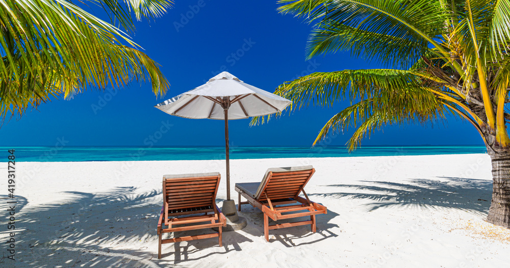 Tropical beach nature as summer landscape with lounge chairs and palm trees and calm sea for beach banner. Luxurious travel landscape, beautiful destination for vacation or holiday. Beach scene
