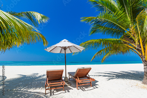 Tropical beach nature as summer landscape with lounge chairs and palm trees and calm sea for beach banner. Luxurious travel landscape, beautiful destination for vacation or holiday. Beach scene  © icemanphotos