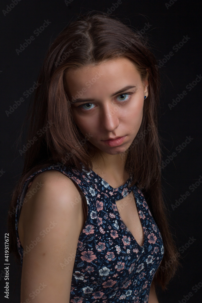 brown-haired woman with long hair, in a blue dress with flowers, on a black background brown-haired woman with long hair, in a blue dress with flowers, on a black background