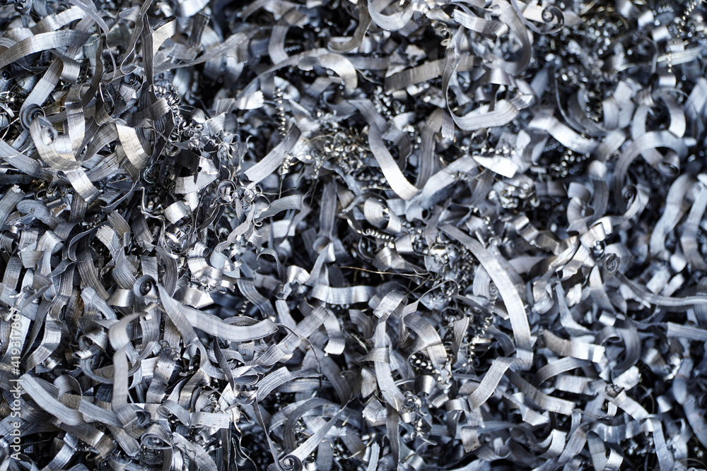 Steel scrap materials recycling. Aluminum chip waste after machining metal parts on a cnc lathe. Closeup twisted spiral steel shavings. Small roughness sharpness, Steel scrap materials recycling. Aluminum chip waste after machining metal parts on a cnc lathe. Closeup twisted spiral steel shavings. Small roughness sharpness,