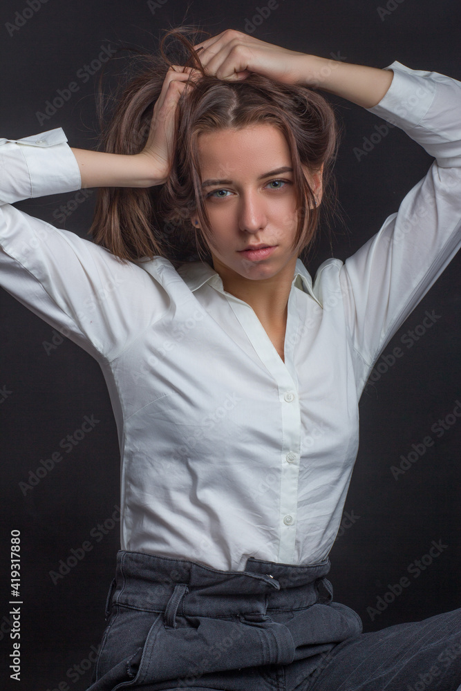 Naklejka premium studio portrait of a young brown-haired woman, on a black background