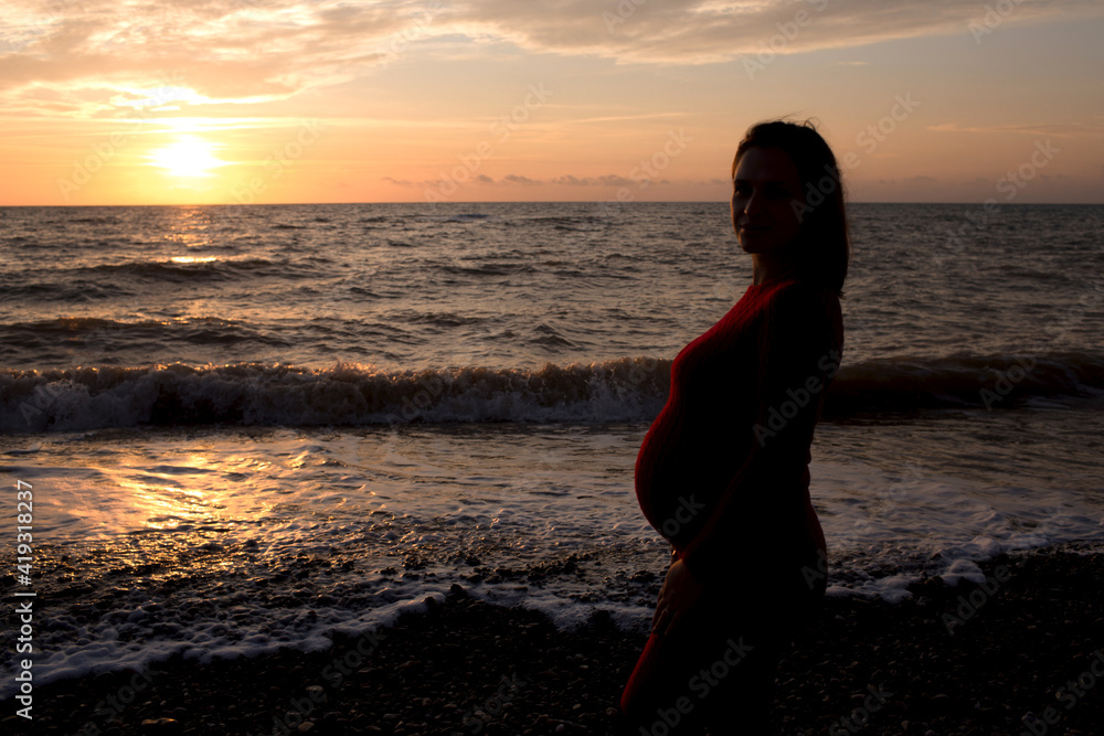 Stylish pregnant woman. Beautiful young pregnant woman enjoying the sunset. Pregnant tummy. The pleasure of pregnancy. Life style. Motherhood.Maternity.