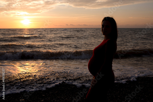 Stylish pregnant woman. Beautiful young pregnant woman enjoying the sunset. Pregnant tummy. The pleasure of pregnancy. Life style. Motherhood.Maternity.