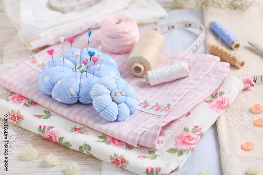 Sewing tools and supplies - handmade pincushion, scissors, bobbins with thread, needles and fabric Sewing tools and supplies - handmade pincushion, scissors, bobbins with thread, needles and fabric