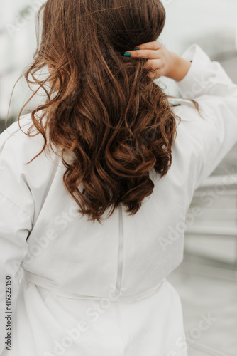 girl with long hair close-up in a white coat back view