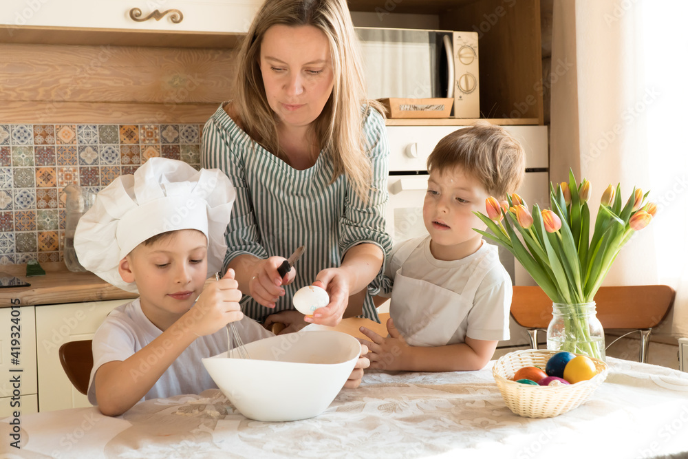 mother and sons little boys baking cookies in kitchen, doing dough for easter cake mother and sons little boys baking cookies in kitchen, doing dough for easter cake