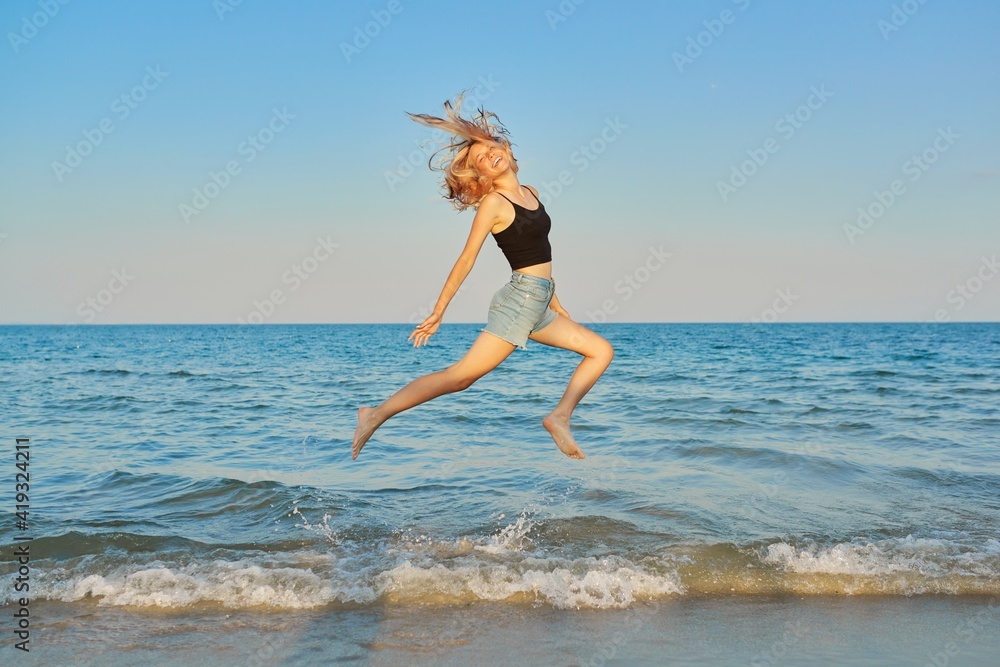 Naklejka premium Young beautiful woman flying over the sea, happy female jumping over water