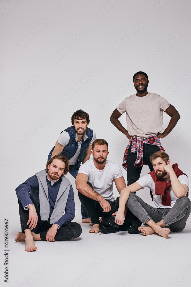 interracial young men isolated on white background, mixed race male models in stylish casual clothes posing at camera while sitting Stock Photo | Adobe Stock