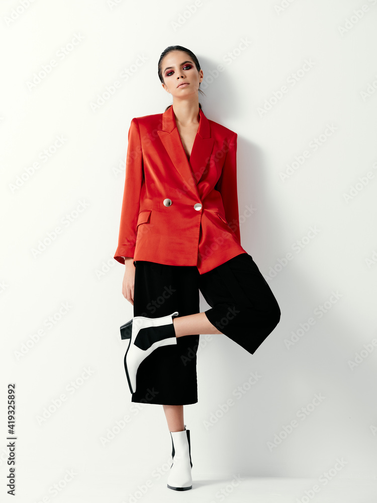 brunette with bright makeup fashionable clothes leg bent at the knee posing brunette with bright makeup fashionable clothes leg bent at the knee posing