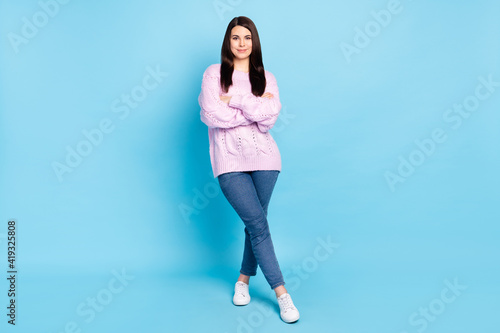 Full size photo of young attractive woman brown hair folded hands confident isolated over blue color background