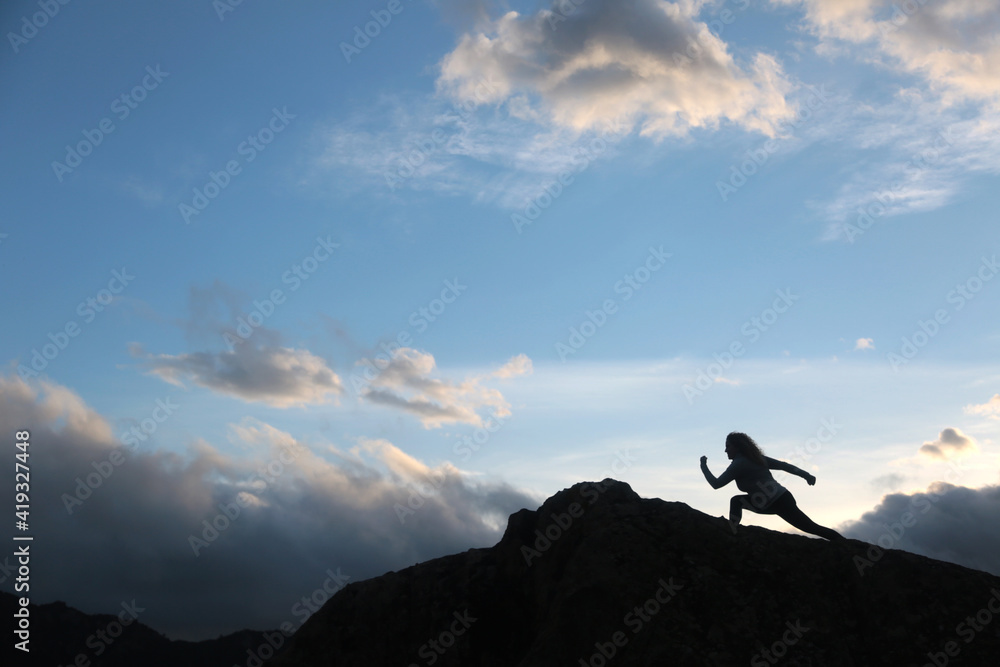 woman with running silohuette in the mountain with background sky with clouds