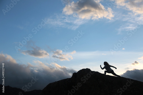 woman with running silohuette in the mountain with background sky with clouds