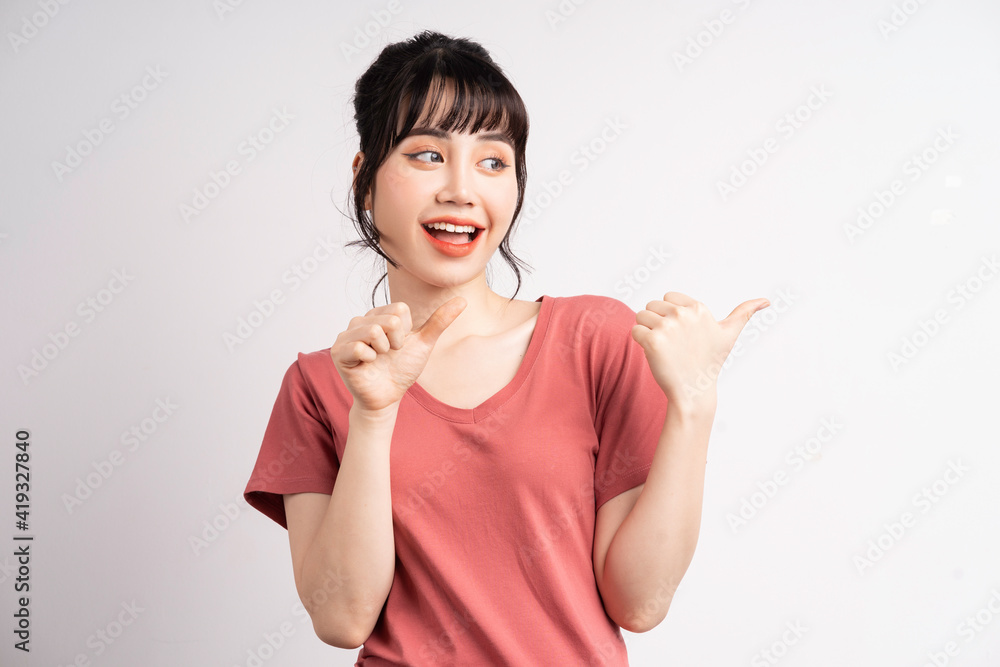 Young Asian woman posing on white background, using finger to pointing and showing, hand gesture Young Asian woman posing on white background, using finger to pointing and showing, hand gesture