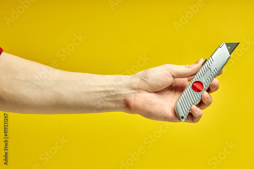 Swiss knife close-up isolated on yellow background, copy space. cutting tools instruments photo