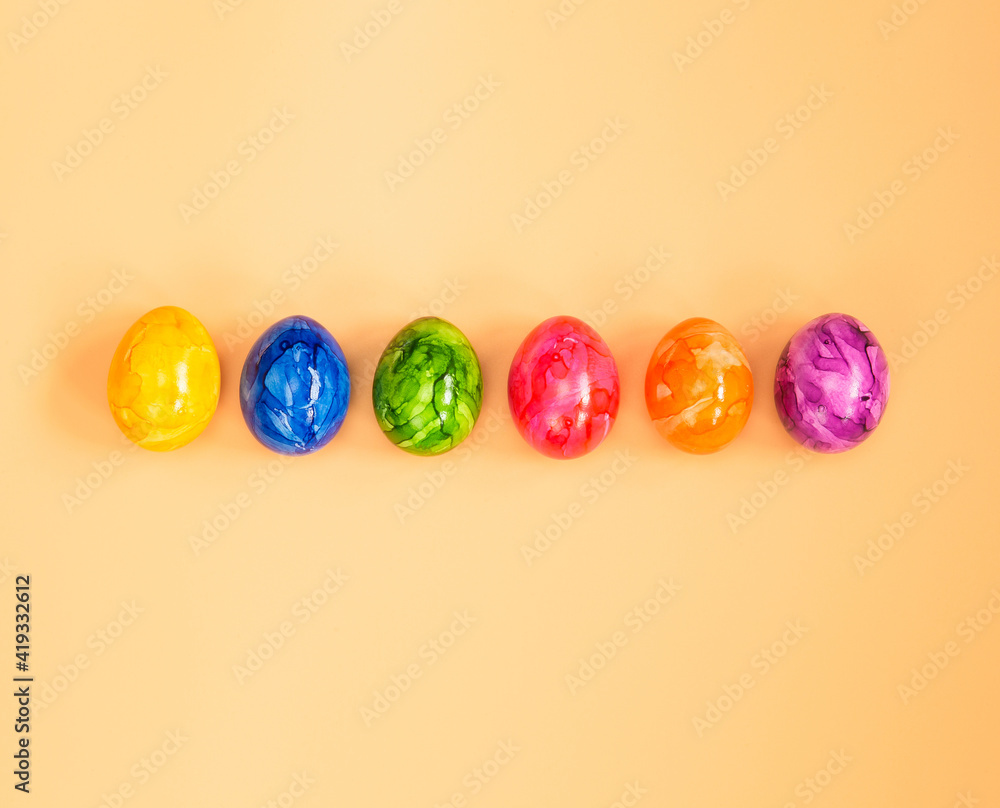Colorful Easter eggs homemade painted top view flatlay on pastel orange peach background bright fresh design, Happy Easter, spring concept Colorful Easter eggs homemade painted top view flatlay on pastel orange peach background bright fresh design, Happy Easter, spring concept