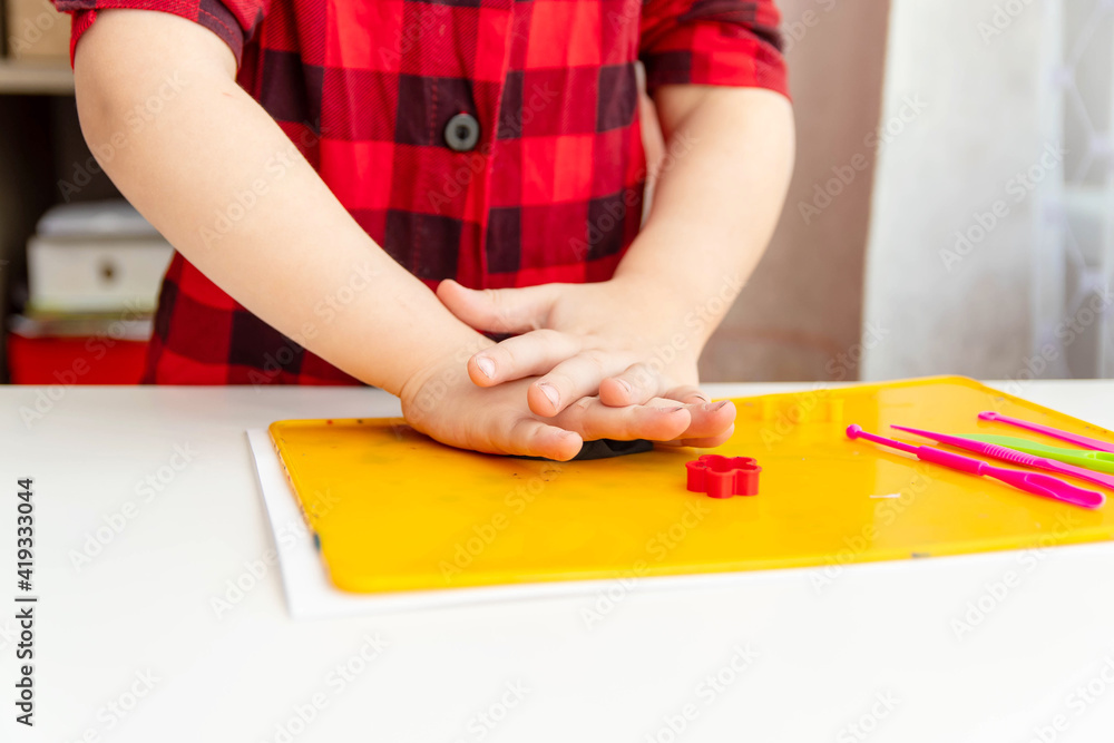 A close-up of the hand of a preschool child sculpts plasticine. Brain development and thinking through sculpting. A close-up of the hand of a preschool child sculpts plasticine. Brain development and thinking through sculpting.
