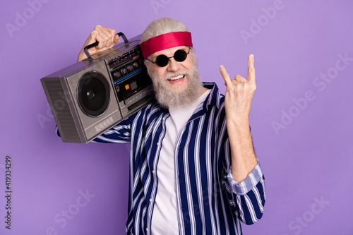 Photo of aged crazy man happy smile hold boombox show rock sign hipster isolated over violet color background