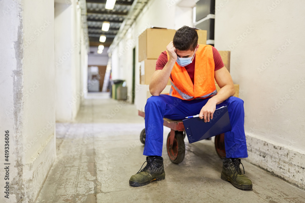 Gestresster Arbeiter mit Mundschutz wegen Covid-19