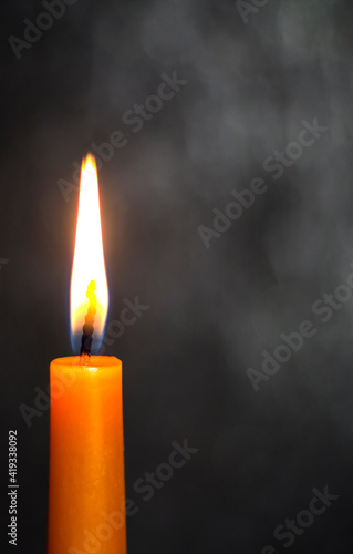 Candle on a dark background. Sorrow. Death.