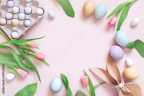 Tender pastel festive Easter card with gift and eggs, decorated with pink tulips