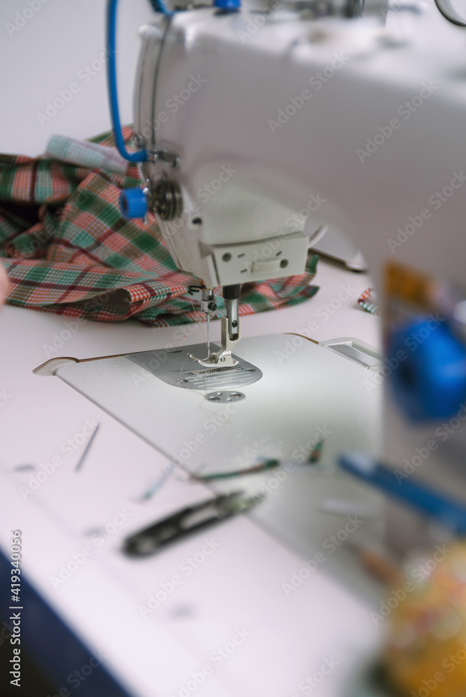 Professional white sewing machine in a tailor workshop