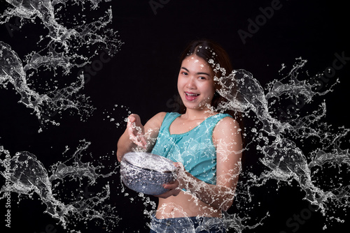 Young happy beauty Asian woman holding plastic water gun at Songkran festival, Thailand. Thai New Year's Day. Isolated on black background.