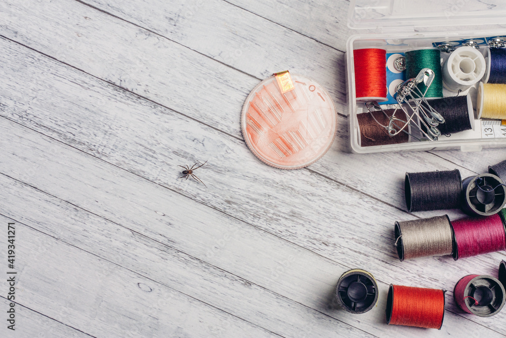 multicolored thread pins on a wooden table sewing accessories Copy Space multicolored thread pins on a wooden table sewing accessories Copy Space
