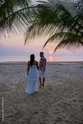 sunrise on the beach with palm trees, Chumphon Thailand, couple watching sunset on the beach in Thailand Asia, mean and woman mid age watching sunrise on beach photo