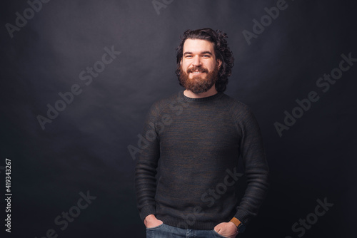 Portrait of handsome bearded hipster man over black background