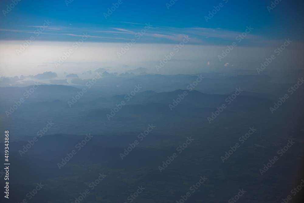 Blurred abstract background from high angle from plane window, overlooking the scenery below (river, mountain, tree).