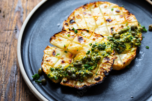 Roasted celeriac steak with capers and herb sauce photo