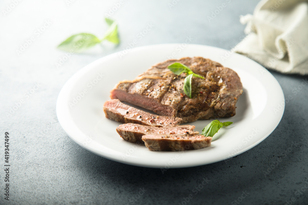 Grilled beef steak with fresh basil