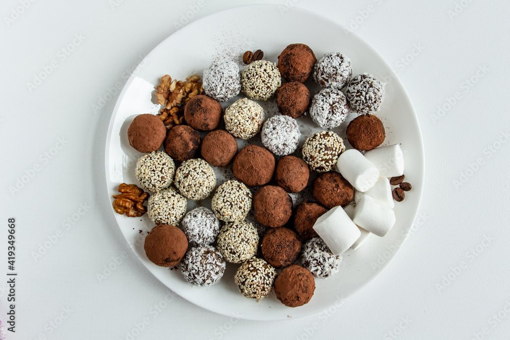 truffles with cocoa, coconut and sesame seeds with chocolate and marshmallows, delicious dessert on a white background