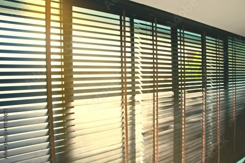 Evening sun light outside wooden window blinds, sunshine and shadow on window blinds , decorative interior home concept