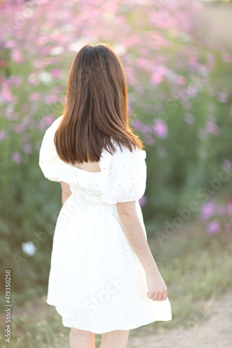 Beautiful young woman with white dress on garden background