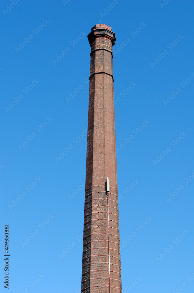 Tall Brick Industrial Chimney seen from  Below against Blue Sky