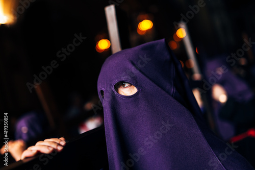 Eyes of a catholic person participating in a holy week procession in seville. Man manifesting his catholic faith on the street in spain. World festival of faith. photo