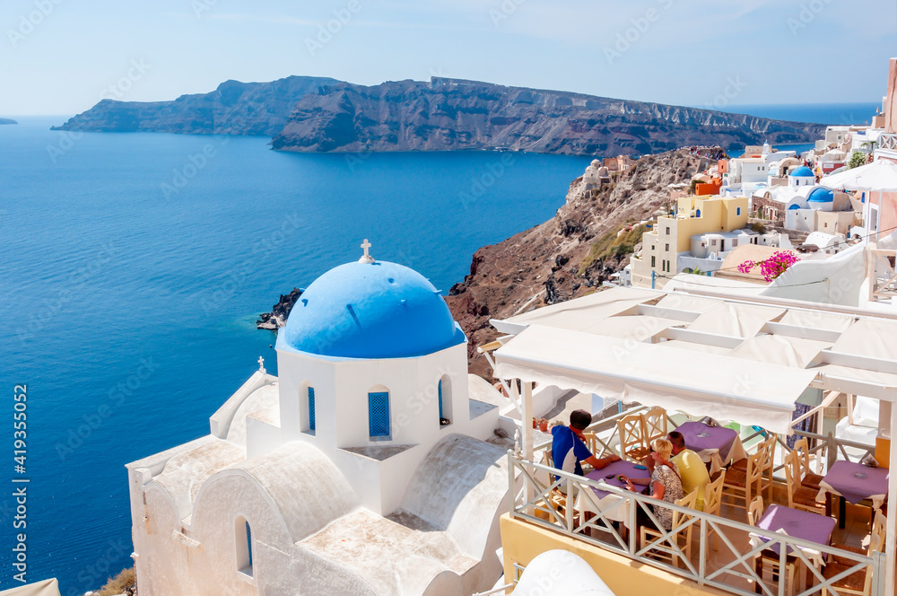 Traditional church and cafe in Oia village, Santorini island, Greece