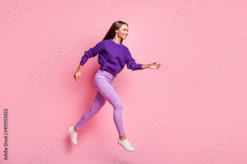 Full size profile photo of optimistic girl jump run wear lilac sweater trousers sneakers isolated on pink background