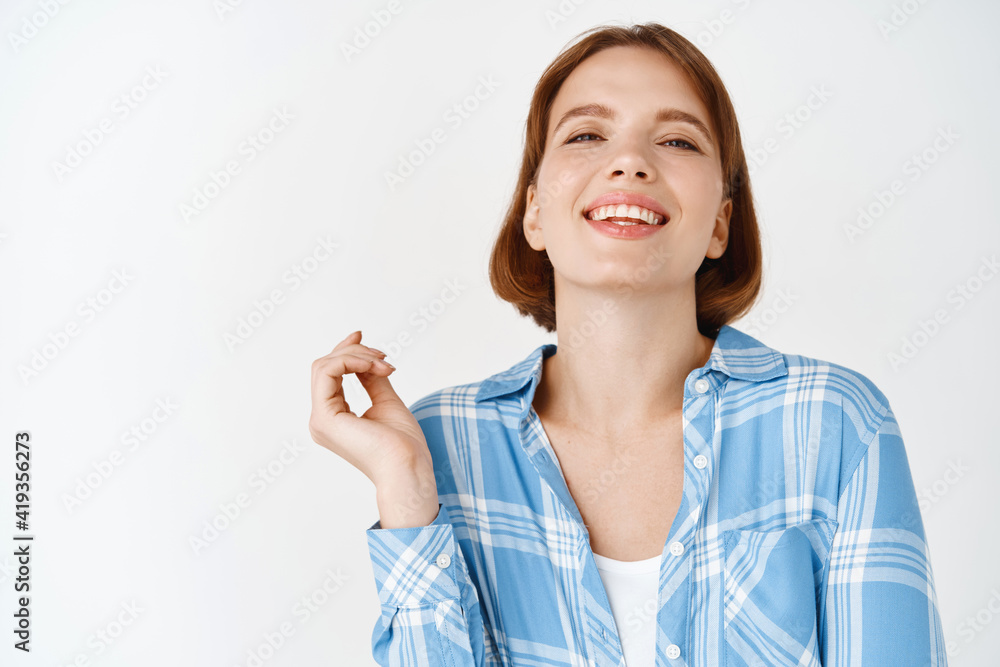Portrait of happy smiling woman, laughing and looking relaxed at camera, standing in casual clothes against white background Portrait of happy smiling woman, laughing and looking relaxed at camera, standing in casual clothes against white background